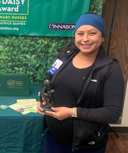 uci health nurse cynthia velasco standing with her DAISY award and certificate